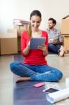 Young Couple With Digital Tablet Resting In Their New Home Stock Photo