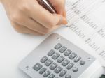 Bookkeeping With Calculator Stock Photo