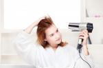 Girl Drying Her Hair At Home Stock Photo
