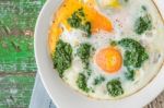 Florentine Eggs With Pureed Spinach On The Wooden Table Stock Photo