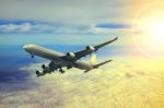 Air Plane Flying Over Cloud Scape And Sun Light Behind Stock Photo
