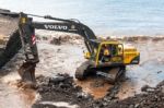 Mechanical Digger Clearing The River Outlet To The Sea From Stor Stock Photo