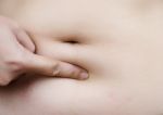 Female Hand Touching Fatty Stomach Stock Photo