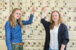 Two Female Students Pointing At Periodic Table In Chemistry Less Stock Photo