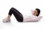 Side Pose Of Laying Exercising Female On White Background Stock Photo