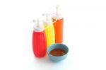 Red Chili Sauce And Three Color Bottle On White Desk Stock Photo