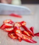 Chillies Being Chopped Indicates Red Pepper And Cayenne Stock Photo