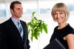 Handsome Boss Passing By Smiling Female Colleague Stock Photo