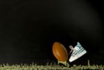 Football On Tee With One Shoe In Black Background Stock Photo