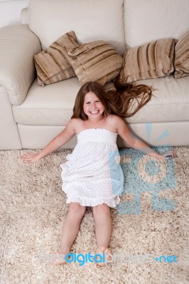 A Girl Sitting On Carpet Stock Photo