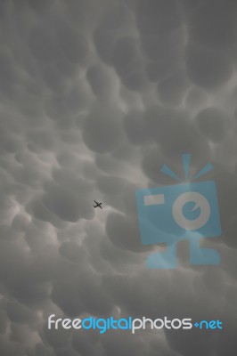 A Plane In Mammatus Clouds Stock Photo