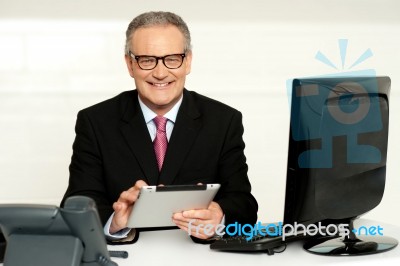 Aged Businessman In Glasses Using Tablet Stock Photo