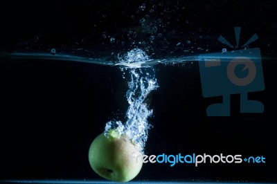 Apple Thrown Into The Water Stock Photo