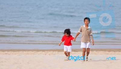 Asian Boys Holding Hands On Beach Stock Photo