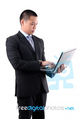 Asian Businessman Holding Laptop Stock Photo