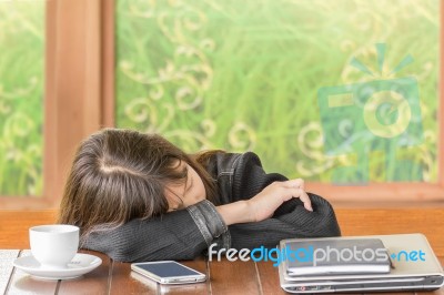 Asian Girl Sleeping While Sitting At Desk Stock Photo