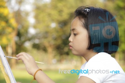 Asian Little Girl Painting In In The Park Stock Photo
