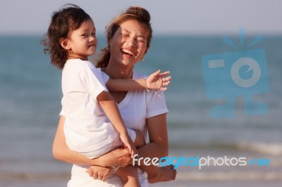 Asian Woman Hold The Boy On Beach Stock Photo