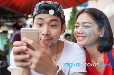 Asian Younger Man And Woman Watching On Smart Phone Use For People And Digital Technology ,wifi And Internet Connection Stock Photo