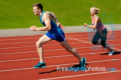 Athletes Running On Race Track Stock Photo