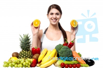 Attractive Fit Smiling Girl Holding Fresh Sliced Oranges Stock Photo