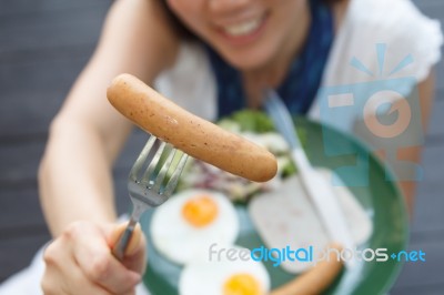 Attractive Woman Giving A Sausage Stock Photo