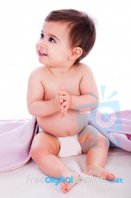 Baby Sitting With A Purple Towel Stock Photo