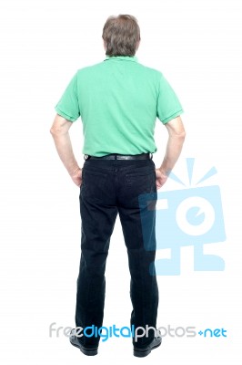 Back Pose Of A Senior Man Looking At The Wall Stock Photo