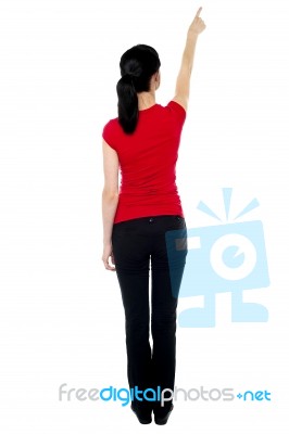Back Pose Of Woman In Casuals Pointing Away Stock Photo
