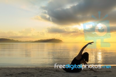 Beautiful Yoga Girl At Sunrise On The Beach Stock Photo