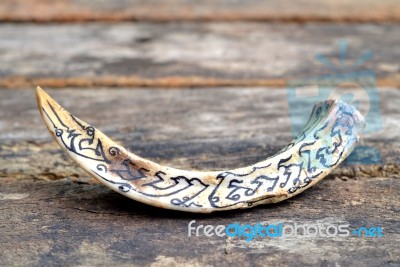 Boar Tusks - Amulet - On Wooden Background Stock Photo