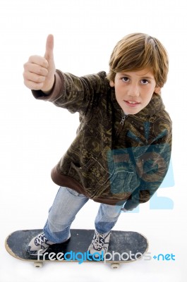 Boy Riding Skateboard And Showing Thumbs Up Stock Photo