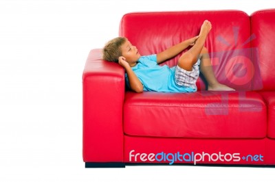 Boy Sleeping On Red Sofa Stock Photo
