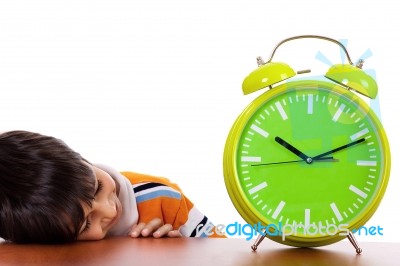 Boy Tired Of Study And Sleeping Near The Clock Stock Photo
