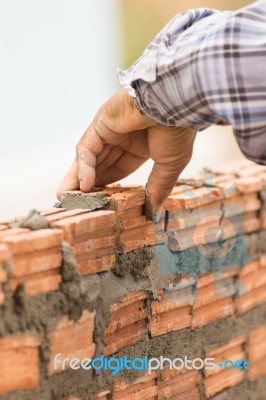 Bricklayer Working In Construction Site Of A Brick Wall Stock Photo