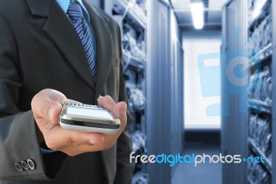 Business Hand Holding Mobile Phone In Network Room Stock Photo
