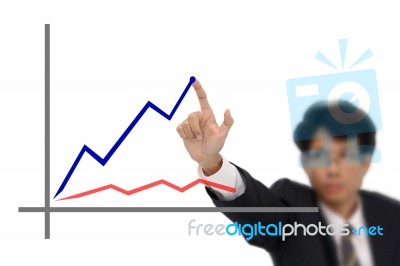 Business Man Point To Top Of Blue Line Graph Stock Photo