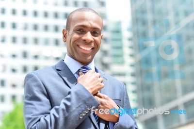 Businessman Adjusting His Collar Outdoors Stock Photo