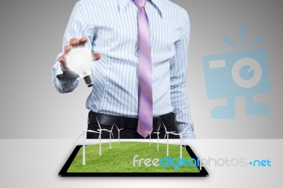 Businessman With Bulb And Windmill Stock Photo