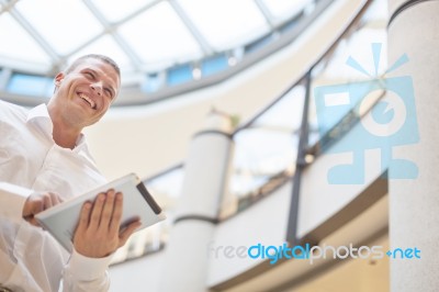 Businessman With Tablet Computer In Modern Business Building Stock Photo