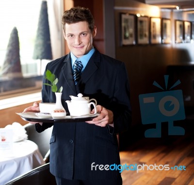 Butler Holding Tea Tray For Guest Stock Photo