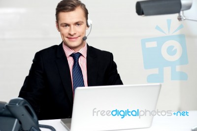 Call Centre Executive Posing With Headsets Stock Photo