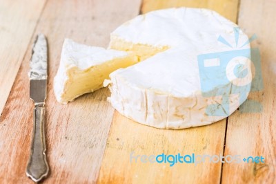 Camembert Cheese With Cut Wedge And Vintage Knife On Wooden Tabl… Stock Photo