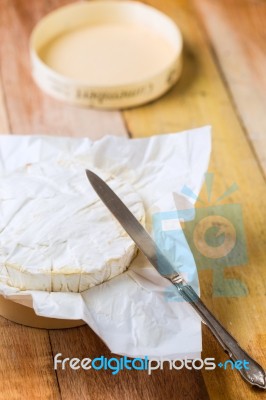 Camembert Cheese Wrapped In Paper With Vintage Knife On Wooden T… Stock Photo