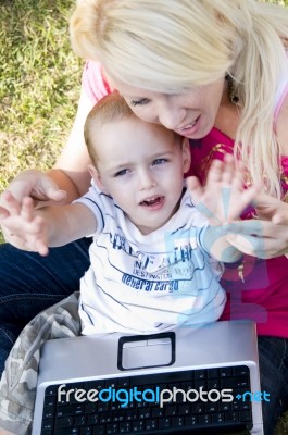 Caring Mother With Laptop And Her Child Stock Photo