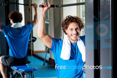 Caucasian Man Sitting On Bench And Exercising Stock Photo