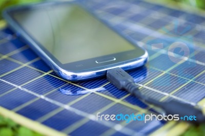 Charging Smart-phone With Solar Charger Stock Photo