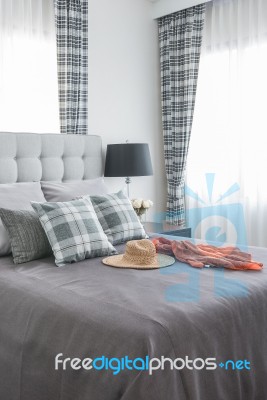 Classic Bed With Pillows, Hat, Cloth And Black Lamp Stock Photo