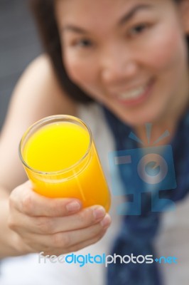 Close Up A Glass Of Orange Juice In Hand Of Young Woman Stock Photo