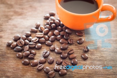 Coffee Beans With Coffee Cup On Wooden Table Stock Photo